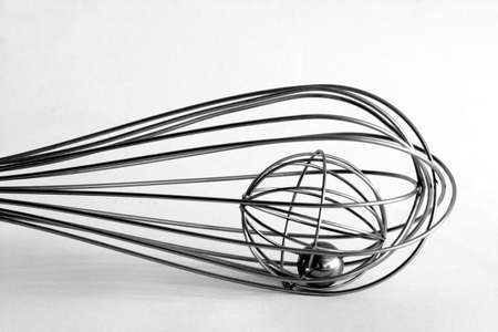 Wired whisk on white surfaceの写真素材