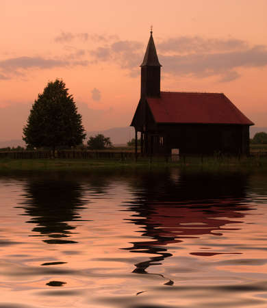Wooden church and tree with reflectionの写真素材
