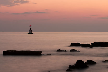 Lighthouse on sea at nightの写真素材