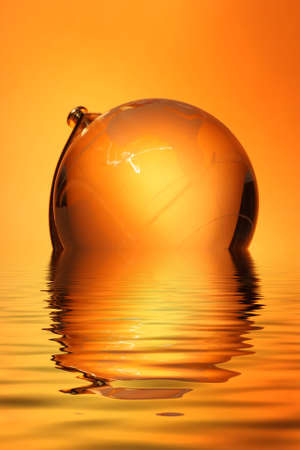 Glass globe with reflection in waterの写真素材