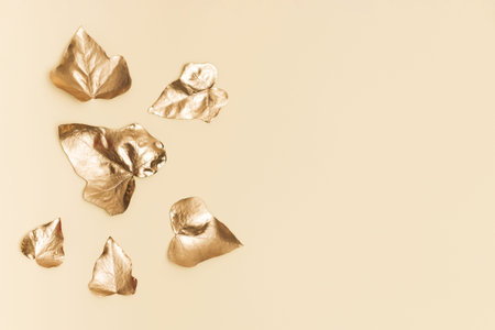 Creative gold background. Ivy leaves on sand color background. Minimal abstract golden composition....
