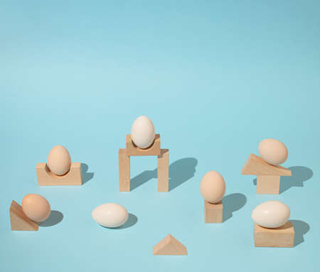Trendy sunlight composition made with eggs and wooden geometric elements on bright light blue background. Minimal architectural concept.の写真素材