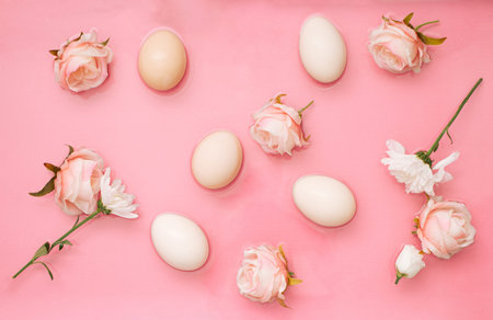 Easter scene with rose flowers and eggs in water. Minimal natural pastel pink background.