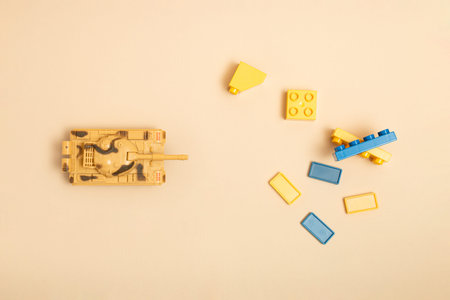 Tank, dominos and toy blocks on sand color background. Minimal Ukraina concept. Top view. Flat lay.の写真素材