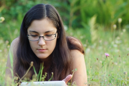woman relaxing in nature and using tabletの写真素材