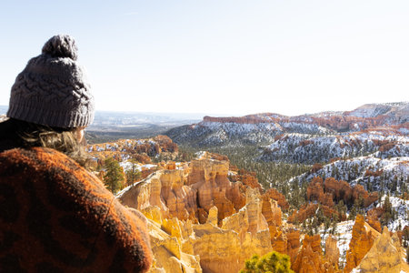 out of focus vertical image of young woman overlooking in focus Bryce canyon national park amphitheater with hoodoos in distanceの写真素材