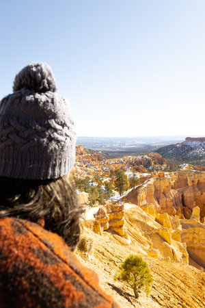 out of focus vertical image of young woman overlooking in focus Bryce canyon national park amphitheater with hoodoos in distanceの写真素材