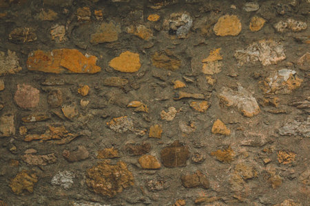 Horizontal stoned rock cobble stone wall with mortar for a textured background abstract material that is slightly dirty vintage and grunge non-uniformの写真素材