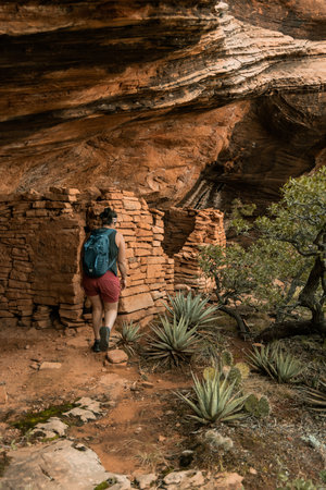 Young 30s woman hikes by cliff dwelling in Boynton canyon Sedona AZ.の写真素材