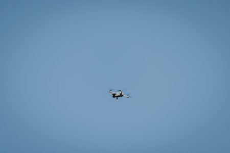 Drone flying in sky against blue background for copy space.