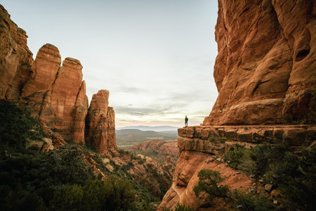 Wide angle view of woman standing at sunset from Cathedral Rock in Sedona.の写真素材