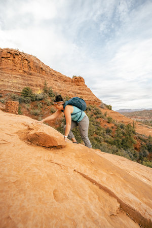 30s woman on all fours hiking up Cathedral Rock Trail in Sedona Arizonaの写真素材