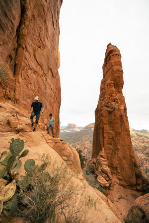 Young couple hiking at Cathedral Rock Summit in Sedona AZ at golden hour.の写真素材