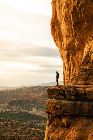 Man stands looking out at amazing dramatic sunset viewpoint from Cathedral Rock.の写真素材