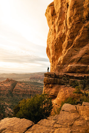 Man stands looking out at amazing dramatic sunset viewpoint from Cathedral Rock.の写真素材