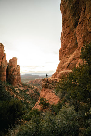 Wide angle view of woman watching sunset in Sedona Arizona from Cathedral Rock Viewpoint.の写真素材
