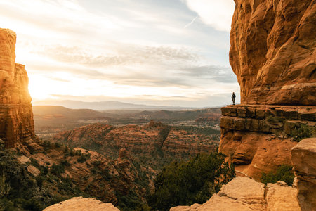 Woman stands looking out at amazing dramatic sunset viewpoint from Cathedral Rock.の写真素材