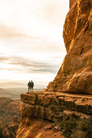 Young couple side by side are on top of Cathedral Rock in Sedona pose for vertical photo.の写真素材