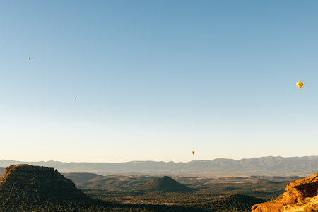 Four hot air balloons in sky floating after early morning take off in Sedona Arizona.の写真素材
