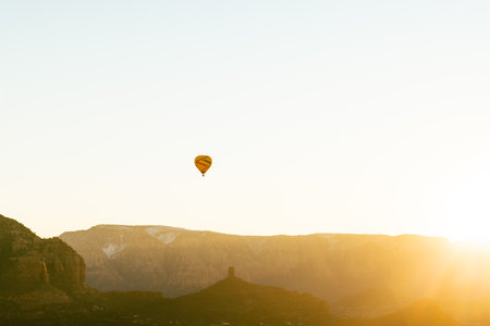Single hot air balloon isolated against white sky at sunrise in Sedona Arizona.の写真素材