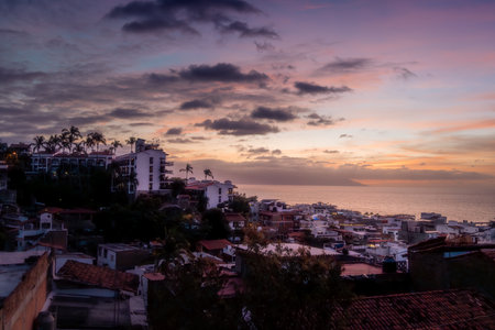 Expansive dramatic sunset over cityscape of Puerto Vallarta Jalisco Mexico in January with orange and purple hues.の写真素材