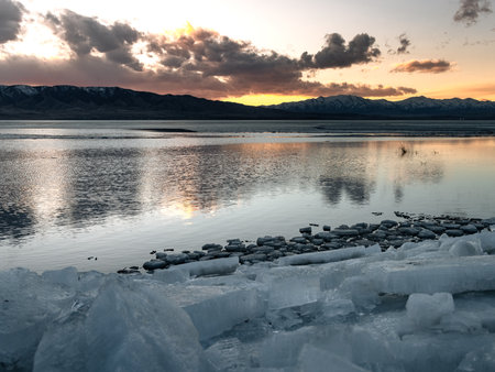 Ice stacks in foreground and bright orange sunset over Utah Lake.の写真素材