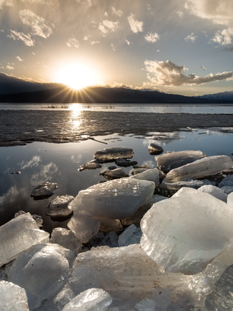 Ice stacks in horizontal image at Vineyard Beach on Utah Lake in Utah at sunset in February 2025.の写真素材