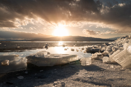 Horizontal photo with Ice stacks in foreground at Vineyard Beach on Utah Lake in Utah at sunset in February 2025.の写真素材