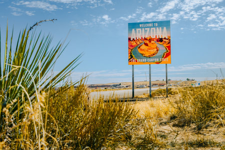 Horizontal image of Arizona State Welcome Sign saying "The Grand Canyon State" with image of Horseshoe Bend with plants in foreground.の写真素材
