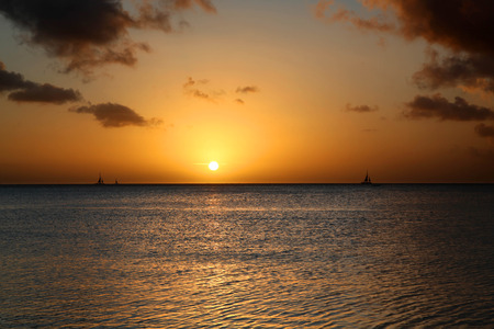 Golden sunset and sailboats at Palm Beach Arubaの写真素材