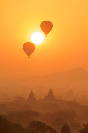 Sunrise of Myanmar\'s Bagan, Darma Yang-JI pagoda next to moments between the two hot air balloons caught in the Sun, forming a singular sightの写真素材