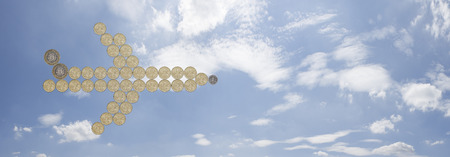 airplane made out of one pound coins with a blue sky background