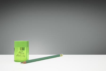 Green wooden pencil and green pencil sharpener with a tree insideの写真素材
