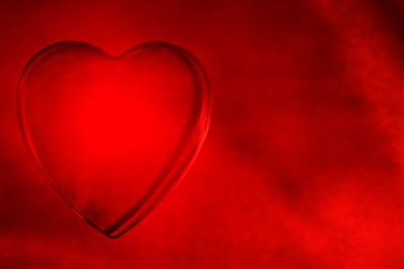 glass love heart on red silk backgroundの写真素材