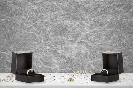Bride and Groom gold and white gold wedding rings in there boxes on a wedding table setting