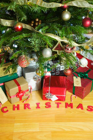 Christmas presents under an illuminated Christmas Treeの写真素材