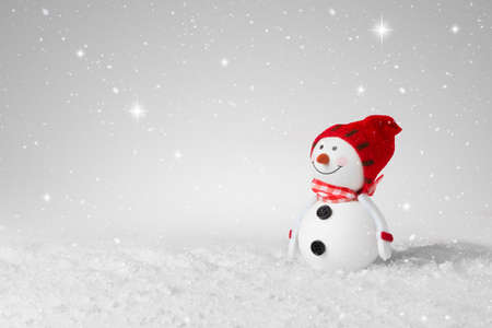 Snow falling on a White Christmas decoration snowmanの写真素材