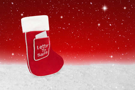 Red Christmas stocking with a letter to Santa in the front pocketの写真素材