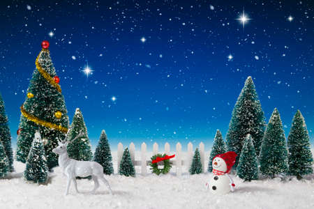 Model Christmas village trees in a fake snow backgroundの写真素材