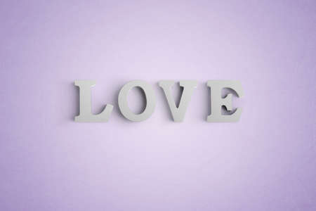 Wooden letters spelling LOVE with a heart shaped white balloonの写真素材