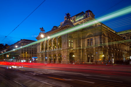 Wide shot of traffic passing in front of the Vienna Opera House on Opernring. Taken early evening in...