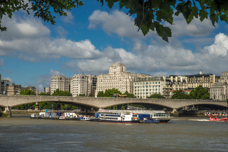 Waterloo Bridge London framed by trees on the south bank of the Thamers. The Shell trading buiidling is in the backgroundのeditorial素材