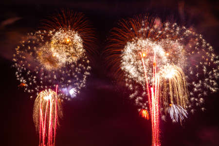 Colorful yellow and red fireworks 4th of July New Year's Eve celebration at night.の写真素材