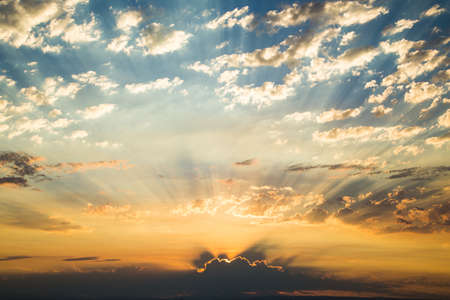 Early morning sunrise with golden god sunlight rays and dramatic clouds.の写真素材