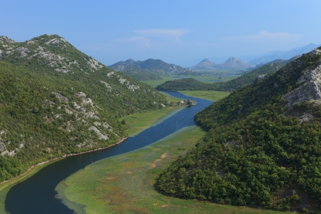 Rijeka Crnojevica river winding through lily pads and mountains in Montenegroの写真素材