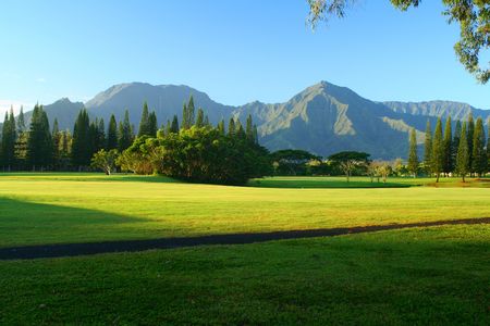 A golf course fairway in the morning with mountains in the background.の写真素材