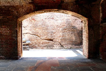 A brick arch way with daylight shinny through.の写真素材