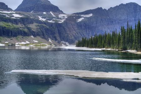 A clear blue high mountain lake with floating ice.の写真素材