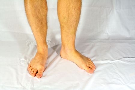 Bare male feet standing on a white cloth.の写真素材