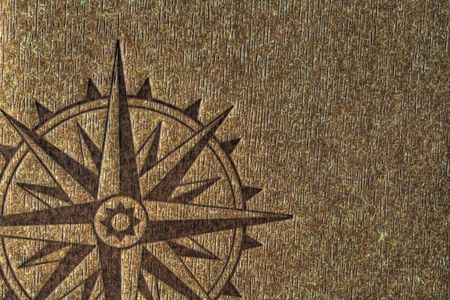 A compass rose imprinted on a wood texture with copy spce.の写真素材